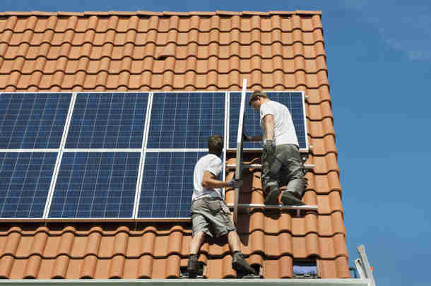 Twee mannen leggen zonnepanelen aan op dak naar aanleiding van formatieonderzoek energiestransitie