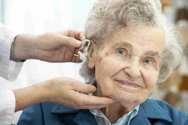 zorgmedewerker oude vrouw gehoorapparaat